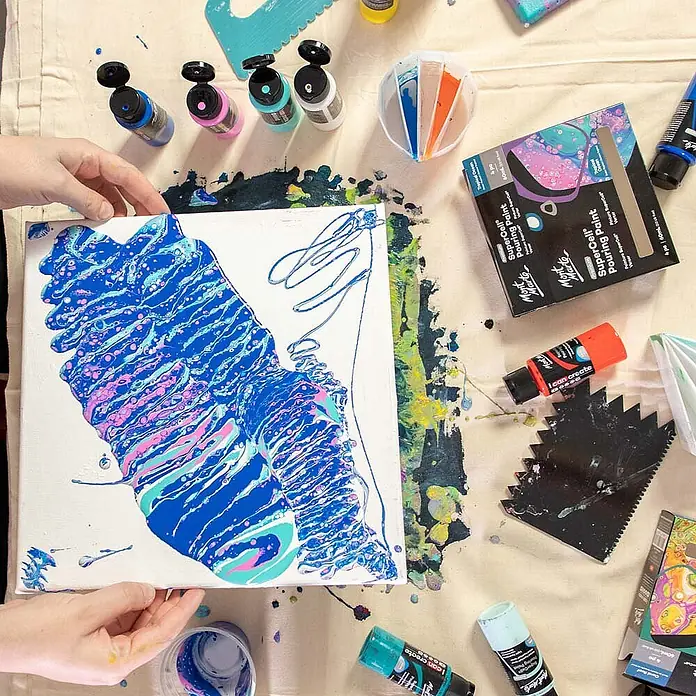 Mont Marte Acrylfarben-Set SuperCell® Tropical Ocean - mehrfarbig, 4 Stk. x 60 ml, Flasche - Acryl-Pouring-Kunst in Arbeit auf einer Leinwand, umgeben von Mont Marte SuperCell Pouring Paint Flaschen, einem segmentierten Becher und Kratzwerkzeugen.