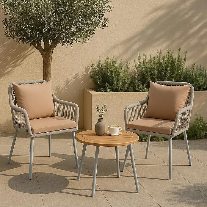 Mendler 2x Gartenstuhl HWC-O12 Rückenpolster - grau, Bezug taupe -  - Outdoor-Patiomöbel-Set mit zwei grauen geflochtenen Stühlen mit beigen Kissen und einem runden hellen Holztisch auf grauen Metallbeinen, auf gefliestem Patio.