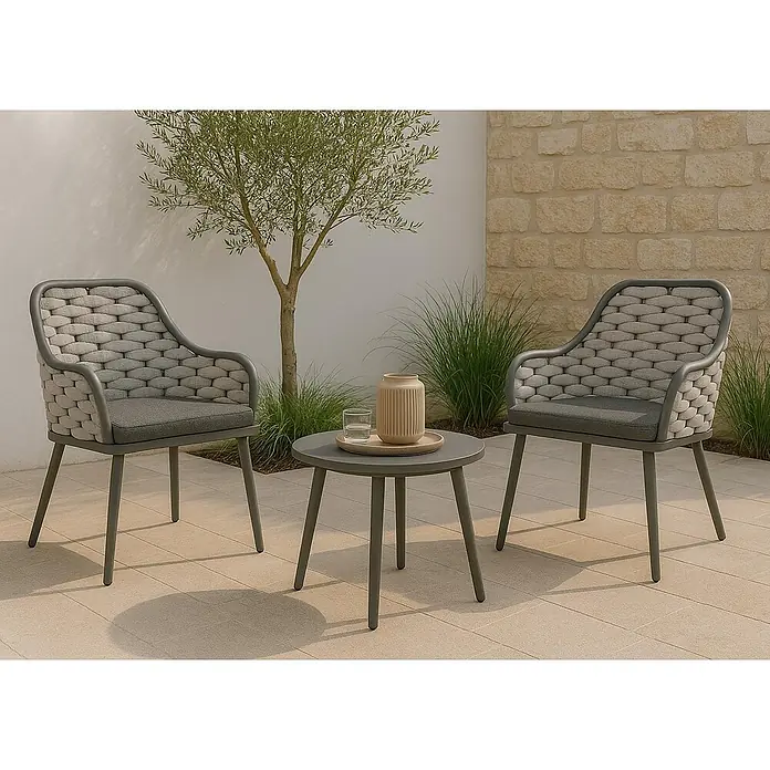 Mendler 2er-Set Aluminium-Gartenstuhl HWC-O16 - hellgrau Kissen dunkelgrau -  - Zwei graue Gartenstühle mit geflochtenen Rückenlehnen und Sitzkissen, und einem passenden runden Beistelltisch auf einer Terrasse.
