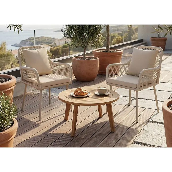 Mendler 2x Gartenstuhl HWC-O12 Rückenpolster - creme, Bezug creme -  - Zwei beige geflochtene Outdoor-Sessel mit Kissen und ein runder Lamellen-Kaffeetisch aus Holz auf einem Balkon mit Meerblick.