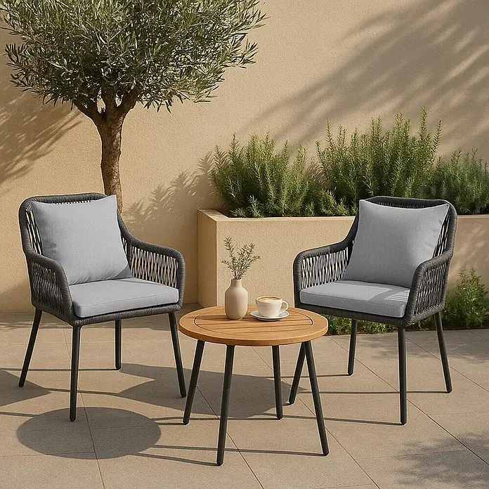 Mendler 2x Gartenstuhl HWC-O12 Rückenpolster - anthrazit, Bezug grau -  - Eine Outdoor-Sitzgruppe mit zwei dunklen Flechtstühlen mit hellgrauen Kissen und einem kleinen runden Holztisch zum Entspannen.