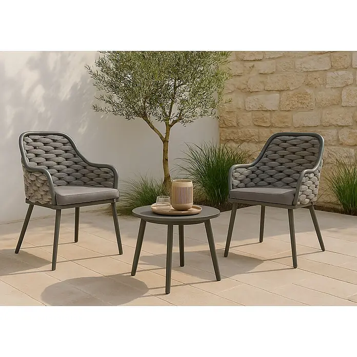 Mendler 2er-Set Aluminium-Gartenstuhl HWC-O16 - anthrazit Kissen dunkelgrau -  - Zwei graue Outdoor-Stühle mit geflochtenen Rückenlehnen und ein passender runder Beistelltisch auf einer Terrasse.