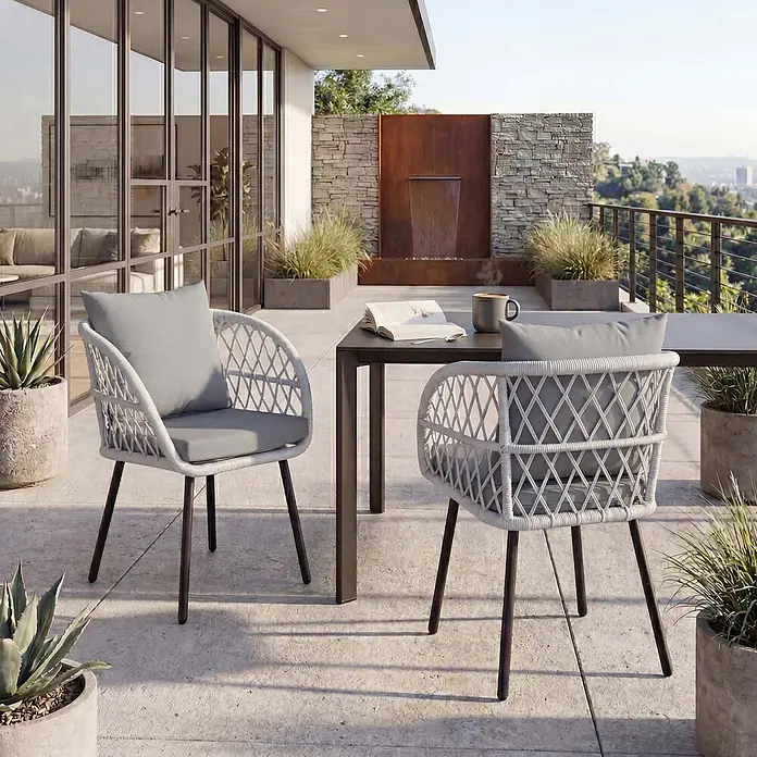 Mendler 2er-Set Gartenstuhl HWC-Q38 - Gestell schwarz, Polster hellgrau -  - Hellgraue geflochtene Outdoor-Stühle mit dunklen Beinen und Kissen, auf einer Terrasse mit Tisch.