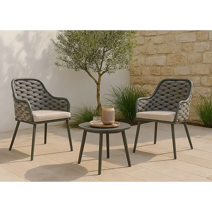 Mendler Gartenstuhl-Set HWC-O16 - 2 Stk., Textil, Anthrazit Kissen taupe, B x T x H: 59 x 63 x 84 cm - Zwei graue Outdoor-Stühle mit geflochtenen Rückenlehnen und beigefarbenen Kissen, die einen runden grauen Beistelltisch auf einer Terrasse flankieren.