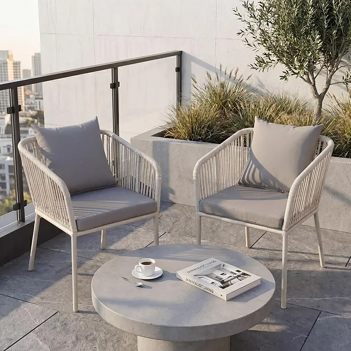Mendler 2er-Set Gartenstuhl HWC-N41 - hellgrau, Kissen hellgrau -  - Zwei moderne Outdoor-Stühle mit grauen Kissen und ein runder Couchtisch im Beton-Stil auf einem Balkon.