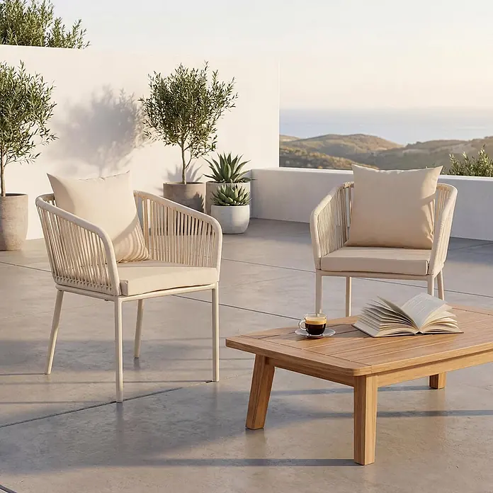 Mendler 2er-Set Gartenstuhl HWC-N41 - Creme, Kissen Creme -  - Zwei cremefarbene Seilstühle mit beigen Kissen und ein Holztisch auf einer Terrasse.
