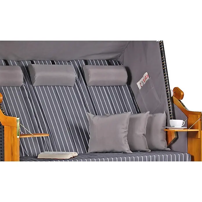 Strandkorb Ostsee XXL Wacholder PE Schwarz Dessin Royal Anthrazit -  - Grau gestreiftes Strandkorb-Interieur mit Kissen, Holztischen, einem Buch und einer Tasse.
