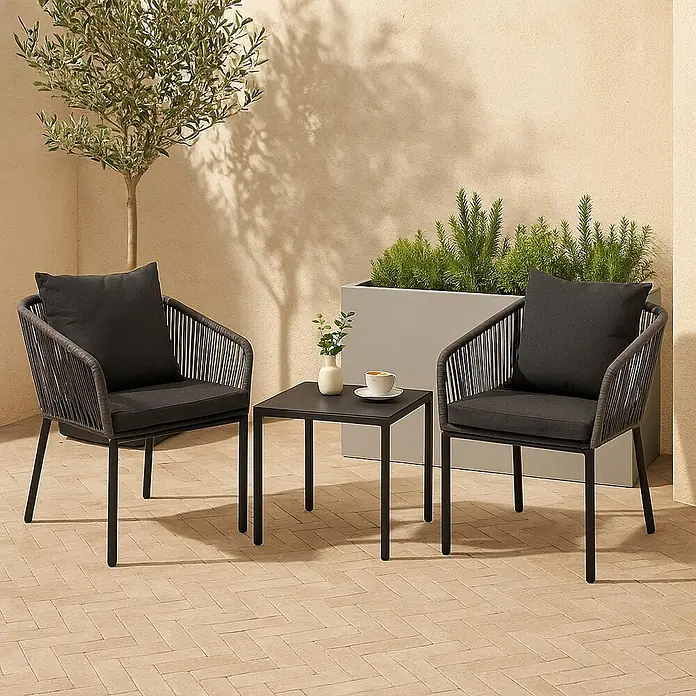 Mendler 2er-Set Gartenstuhl HWC-N41 - anthrazit, Kissen dunkelgrau -  - Zwei dunkelgraue Outdoor-Stühle mit Seildetails und passenden Kissen, die einen kleinen quadratischen dunkelgrauen Metalltisch auf einer Terrasse umrahmen.