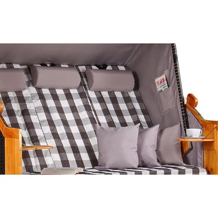 Strandkorb Ostsee XXL Wacholder PE Schwarz Dessin Grau Kariert -  - Detailansicht eines Strandkorbs mit braun-weiß karierter Polsterung, grauen Kissen, Holztischen, Tasse und Buch.
