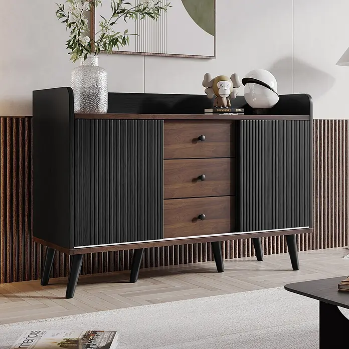 SONNENH Kommode - Schwarz/Holzoptik, Anzahl Schubladen: 3 Stk. - Modernes Sideboard aus dunklem Holz und Schwarz mit geriffelten Türen, drei Schubladen und schrägen Beinen, dekoriert in einem Wohnzimmer.