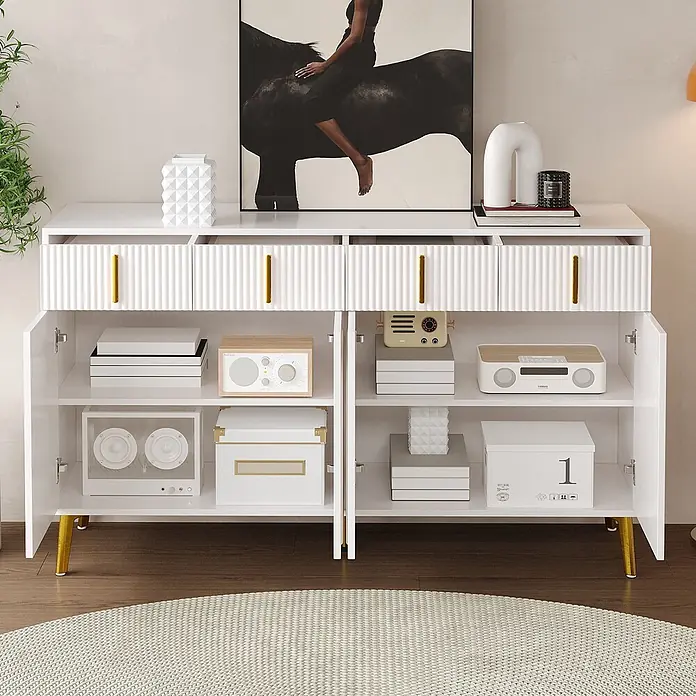 SONNENH Kommode - Weiß/Gold, Anzahl Schubladen: 4 Stk. - Weißes geriffeltes Sideboard mit goldenen Griffen und Beinen, präsentiert Dekorationen und Mediengeräte in einem modernen Raum.