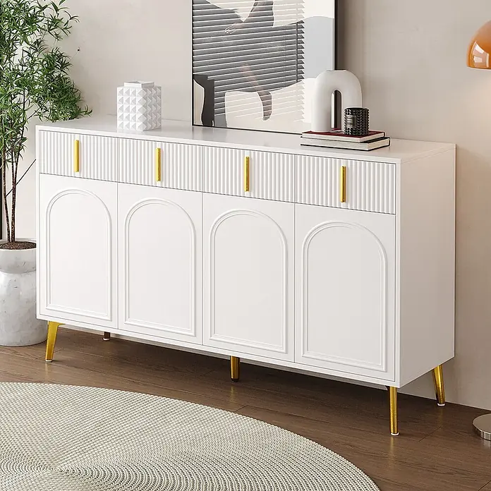 SONNENH Kommode - Weiß/Gold, Anzahl Schubladen: 4 Stk. - Weißes Sideboard mit geriffelten Schubladen und gewölbten Türen, mit goldenen Griffen und Beinen, in einem modernen Wohnraum.