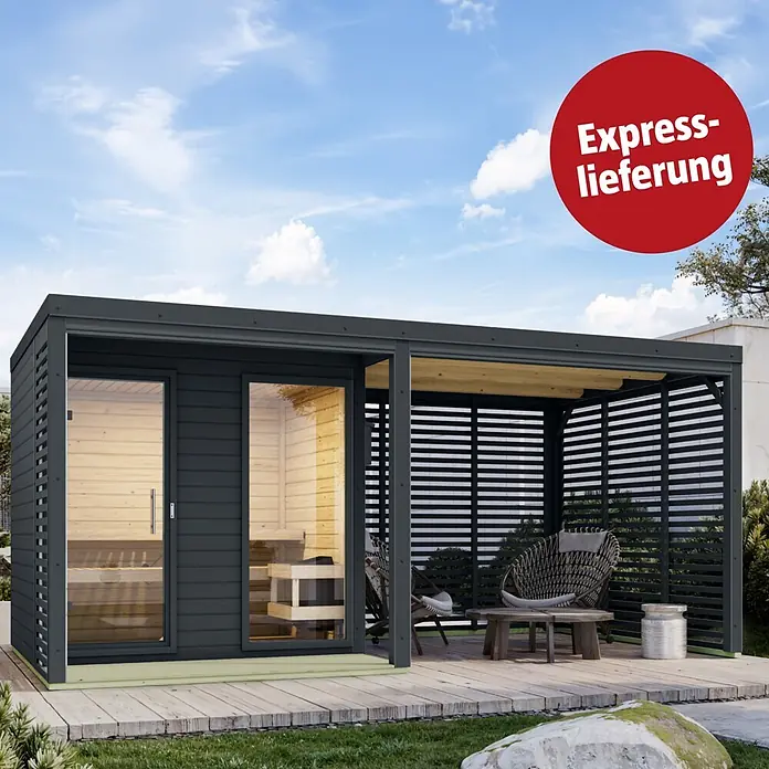 Karibu Saunahaus Heimdall - 9 KW Ofen mit interner Steuerung, Anthrazit, L x B x H: 276 x 492 x 231,5 cm - Dunkelgraue Outdoor-Sauna mit integriertem Lamellen-Loungebereich auf einem Holzdeck im Garten.
