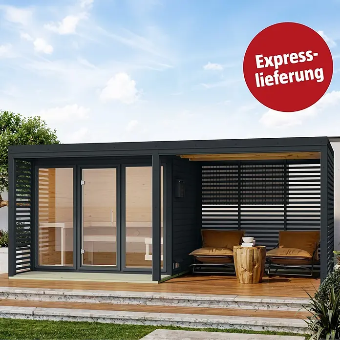 Karibu Massivholzsauna Heimdall - Elektroofen, Steuerung Ofen: Integriert, L x B x H: 537,5 x 276 x 231,5 cm - Dunkelgraue Außensauna mit Glastüren und integriertem Loungebereich mit zwei Stühlen und einem Holztisch, auf Holzterrasse im Garten.