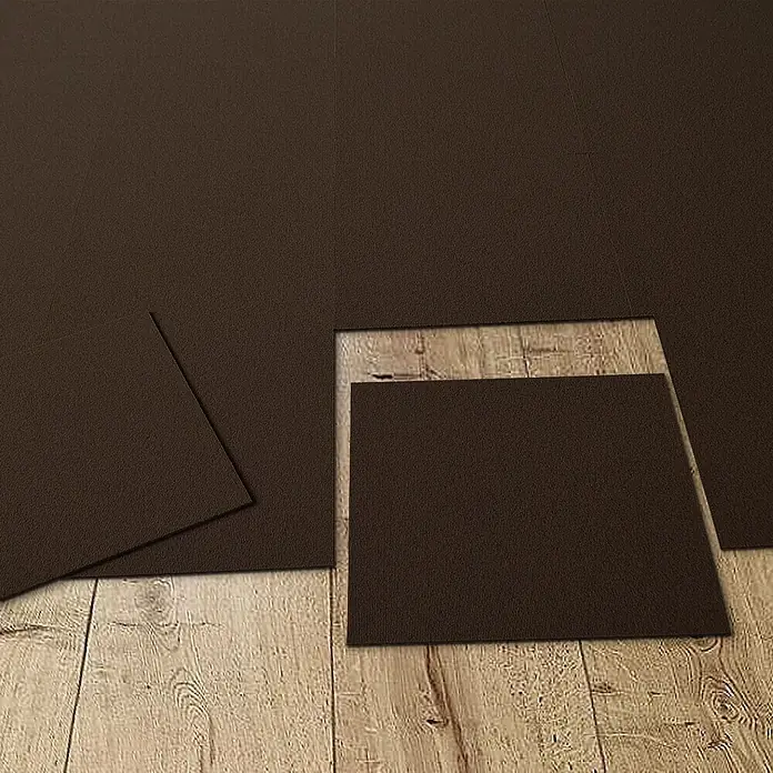 Floordirekt Teppichfliese Lyonn Braun 50 x 50 cm 0,25 m² -  - Dunkelbraune, strukturierte Puzzlematten werden auf einem hellen Holzfußboden verlegt.