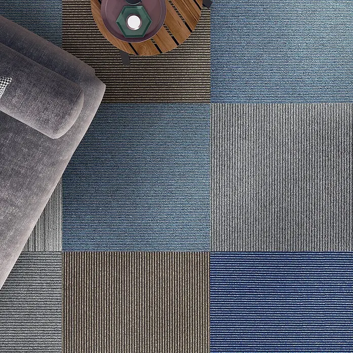 Floordirekt Teppichfliese Bohemia - 50 x 50 cm - 0,25 m² - Grau -  - Modulare Teppichfliesen in Blau, Grau und Braun mit Streifenmustern, auf einem Boden neben Sofa und Tisch.