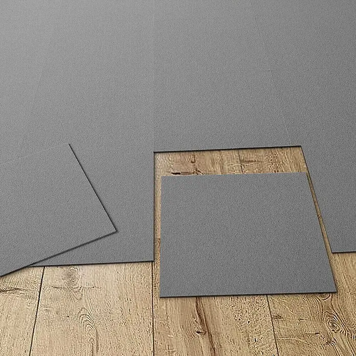 Floordirekt Teppichfliese Lyonn - 50 x 50 cm - 0,25 m² - Hellgrau -  - Graue, strukturierte Bodenfliesen teilweise auf einem Holzfußboden verlegt, die flexiblen Fliesen bedecken die Oberfläche.
