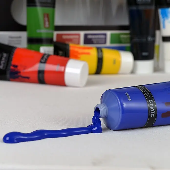Crylic 6x 120 ml Acrylfarben Set - 720ml - Blauer Acrylfarbtube, der leuchtblaue Farbe auf eine weiße Leinwand kleckert. Tube ist mit "Crylic 120ml" beschriftet.