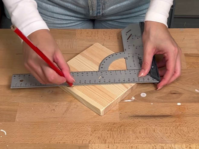 Holzblock wird gemessen und Bleistift markiert