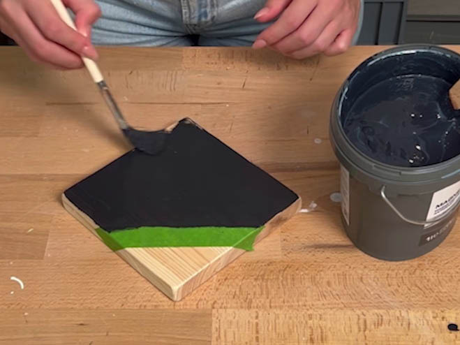 Holzblock wird auf einem Teil mit Magnetfarbe angemalt
