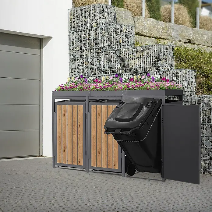ML-Design Mülltonnenbox 3er 240L mit Pflanzdach Anthrazit-Holzoptik -  - Dunkelgraue Metall-Mülltonnenbox mit hellen Holzpaneelen und Blumenpflanzgefäß oben, ein Fach offen mit gekippter Mülltonne.