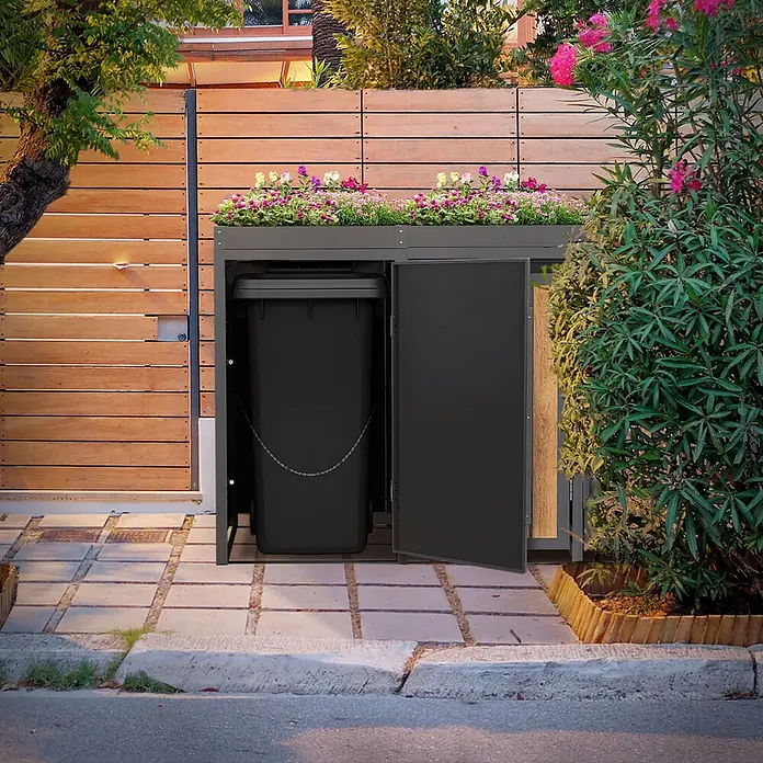 ML-Design 4x Mülltonnenbox 240L Pflanzdach Anthrazit-Holzoptik 260x80x124cm -  - Dunkelgraue Mülltonnenbox aus Metall mit Blumenbeet und farbenfrohen Blumen, die eine schwarze Mülltonne im Außenbereich beherbergt.