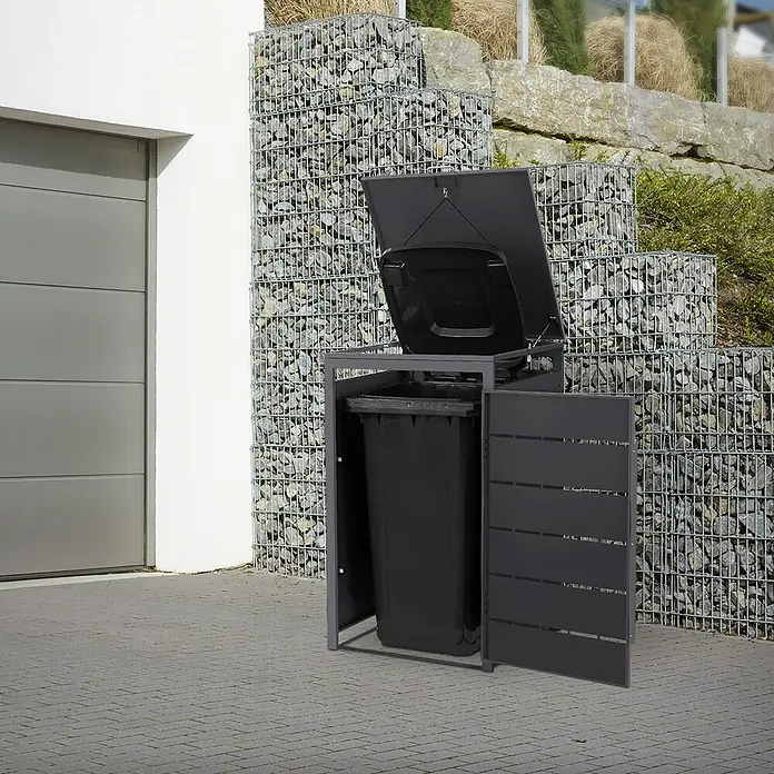 Mülltonnenbox 1er 240L 68x80x120 cm Anthrazit aus Stahl wetterfest -  - Dunkelgraue Mülltonnenbox mit geöffnetem Deckel und Seitentür, die eine schwarze Mülltonne zeigt, draußen auf einer gepflasterten Auffahrt.