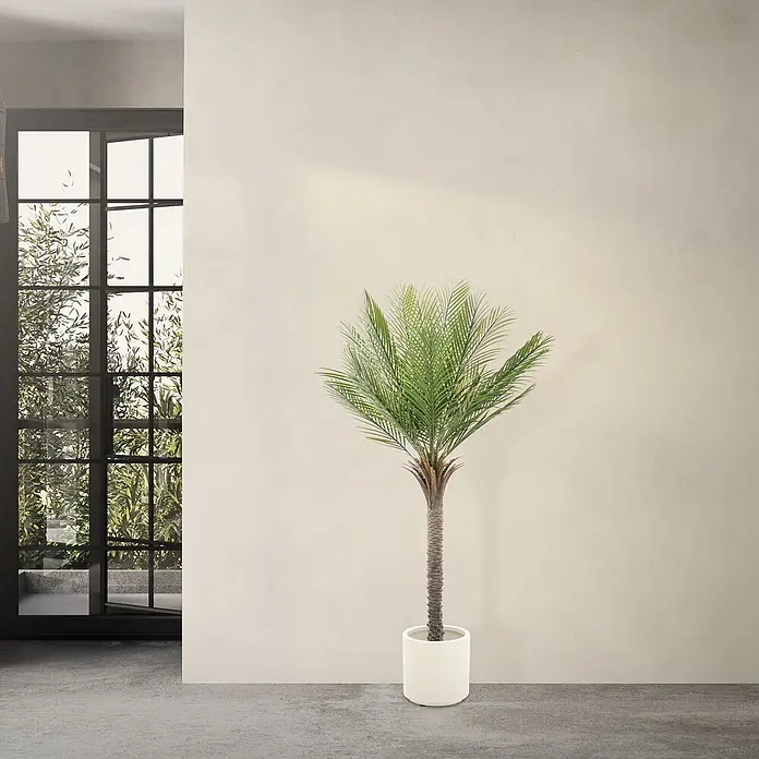 Künstliche Palme 150 cm groß im Topf für Indoor/Outdoor -  - Ein hoher Topfpalme mit üppigen grünen Wedeln und einem schlanken braunen Stamm in einem weißen Pflanzgefäß, in einem hellen modernen Raum.