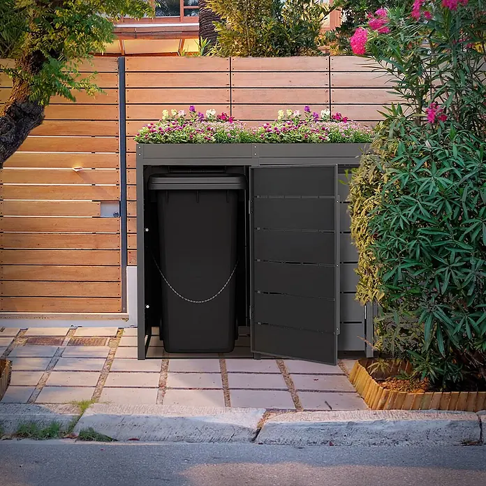 Mülltonnenbox 4er mit Pflanzdach 240L 260x80x124cm Anthrazit aus Stahl -  - Dunkelgraue Mülltonnenbox mit Pflanzdach, beherbergt eine schwarze Mülltonne, neben einem Holzzaun.