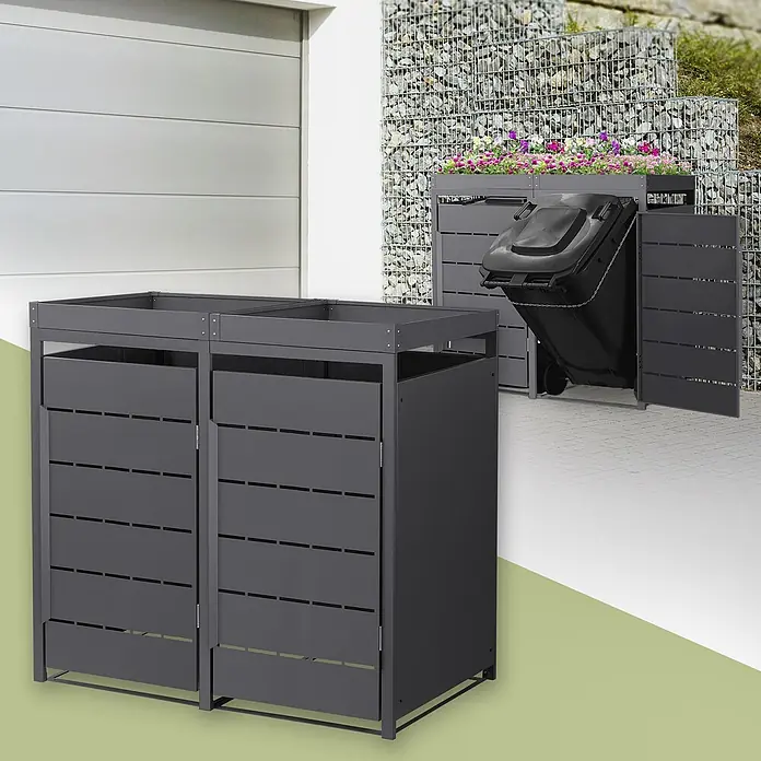 Mülltonnenbox 2er mit Pflanzdach 240L 132x80x124cm Anthrazit aus Stahl -  - Dunkelgraue Mülltonnenboxen aus Metall, eine mit Abfalltonne, offener Tür und Blumen bepflanzt, eine weitere als Doppelbox.