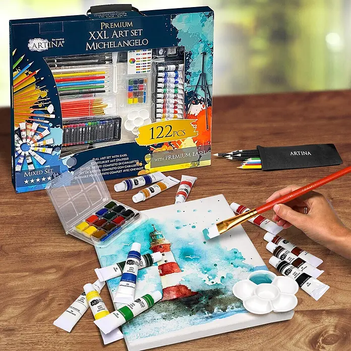 122tlg XXL Malset mit Staffelei Michelangelo, 122tlg. -  - Ein Artina XXL Kunstset mit 122 Teilen (Farben, Pinsel, Stifte) auf einem Holztisch, eine Künstlerin malt einen Leuchtturm auf Leinwand.