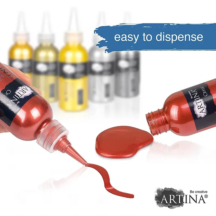Artina Acrylfarben-Set Crylic -  - Eine Hand drückt eine rote ARTINA Metallic-Acrylfarbflasche, die einen Farbstrom abgibt. Eine weitere Flasche liegt seitlich mit einer Pfütze Farbe.