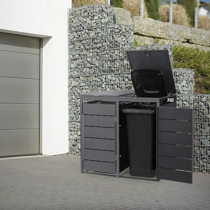 Mülltonnenbox 2er 240L 132x80x120 cm Anthrazit aus Stahl wetterfest -  - Dunkelgraue Mülltontenbox aus Metall mit geöffnetem Deckel und Tür, die eine schwarze Mülltonne zeigt, auf Pflastersteinen.