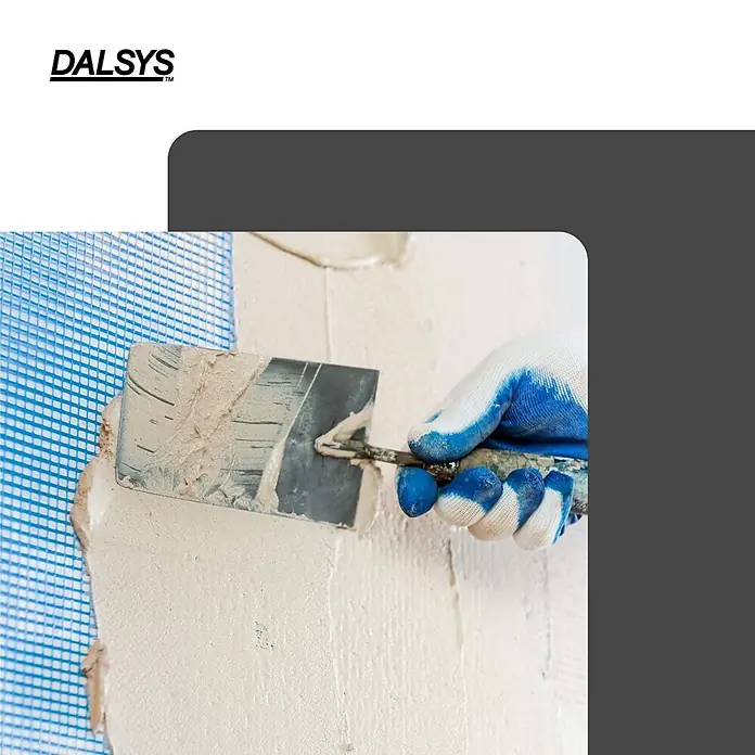 Dalsys Armierungsgewebe - 0,33 x 45 m, Glas - Hand im Handschuh trägt DALSYS Putz mit einer Kelle auf blaues Bewehrungsnetz auf.