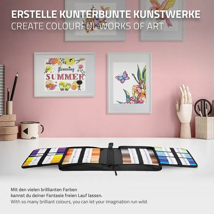 Dual Brush Pen Set 120 Farben Wasserbasis -  - Offene schwarze Tasche mit vielen bunten Markern auf einem Schreibtisch mit Kunstwerken.
