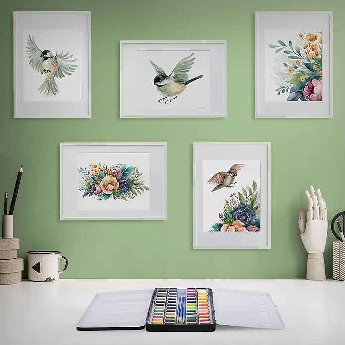 Aquarellfarben Set 48 Farben in tragbarer Box inkl. Utensilien -  - Offener Aquarellkasten mit Farbnäpfchen und Pinseln auf einem Schreibtisch, umgeben von Kunstdekor.