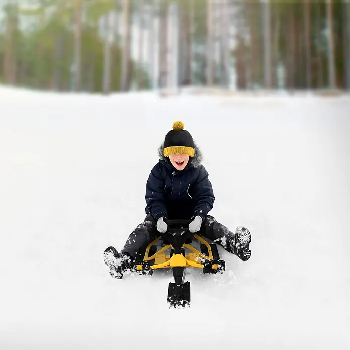 Lenkschlitten für Kinder Gelb 119 x 38 x 50 cm Stahlrahmen bis 90 kg -  - Fröhliches Kind fährt einen gelb-schwarzen Lenkschlitten einen verschneiten Hügel hinunter.