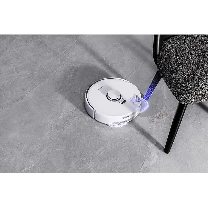 Narwal Saugwischroboter Freo Z10 ultra Extend - Saugkraft: 18.000 Pa, Akkulaufzeit: 150 min, Fassungsvermögen Roboter: 2.500 ml - Weißer Roboterstaubsauger wischt grauen Fliesenboden, blaues Leuchten am Pad betont Reinigung neben dunklem Stuhlbein.