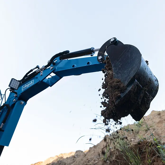 Scheppach Miniexcavadora EXC815 - 6,3 kW, Ángulo de giro del brazo: -70 ° - 70 °, Gasolina, Color azul - Brazo de excavadora azul con cucharón negro excavando y volcando tierra, demostrando su función.