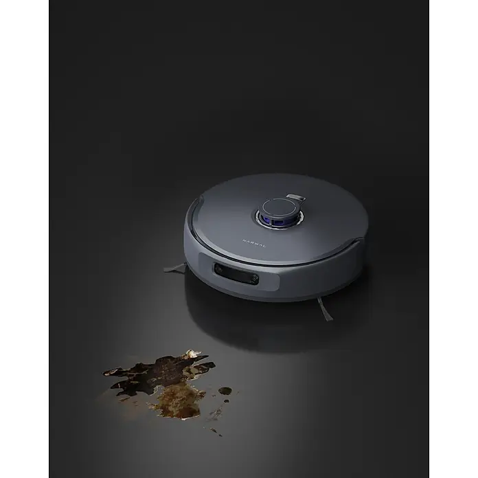 Narwal Saugwischroboter Freo Z ultra - Saugkraft: 12.000 Pa - Dunkelgrauer Narwal Saugroboter mit blau beleuchtetem LiDAR-Sensor und Frontkamera, vor einer dunklen Verschmutzung auf dem Boden.