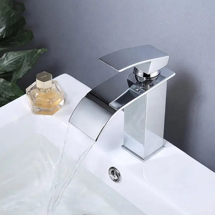 SONNENH Waschtischarmatur - Chrom - Verchromte Wasserfall-Armatur mit rechteckigem Sockel und gebogenem Auslauf, Wasser fließt in weißes Waschbecken.