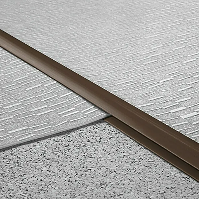 LOGOCLIC Doppeleinfassleiste - Braun, 1 m x 24 mm x 6 mm, Montageart: Kleben - Übergangsprofil zwischen zwei verschiedenen Bodenbelägen, grau gemustert und gesprenkelt, mit braunem Profil.
