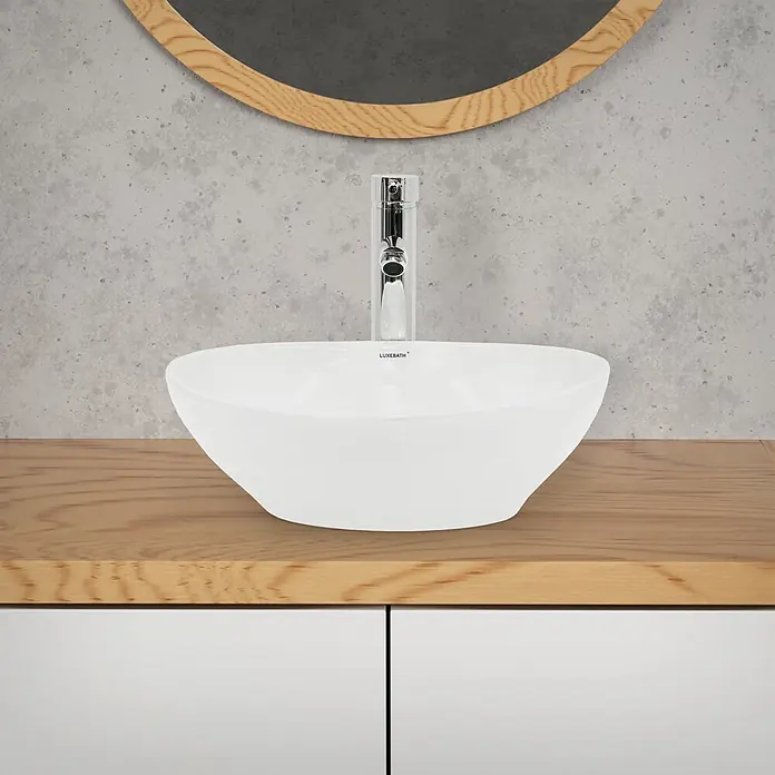 LuxeBath Aufsatzwaschbecken Aufsatzwaschtisch Waschschale Oval Weiß Spülbecken - Ohne Spezialglasur, Weiß - Weißes Keramik-Aufsatzwaschbecken mit Chromarmatur auf Holzplatte.