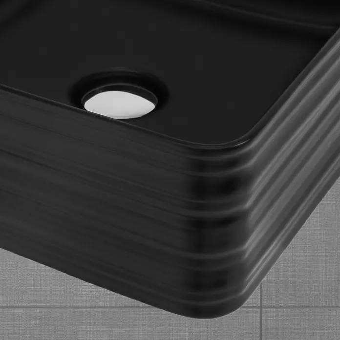 LuxeBath Aufsatzwaschbecken Waschtisch aus Keramik für Badezimmer / Gäste-WC - Ohne Spezialglasur, Schwarz - Nahaufnahme eines schwarzen rechteckigen Waschbeckens mit gerillter Außenseite, abgerundeten Ecken und weißem Abfluss.