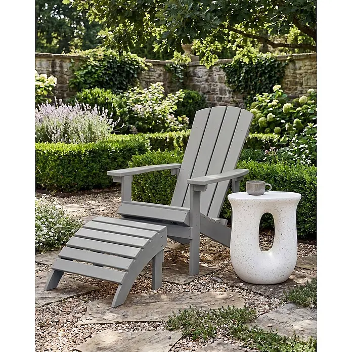 2-tlg Gartenstuhl ADIRONDACK in Grau -  - Graues Adirondack-Stuhl- und Ottoman-Set mit weißem Beistelltisch auf Gartenweg.