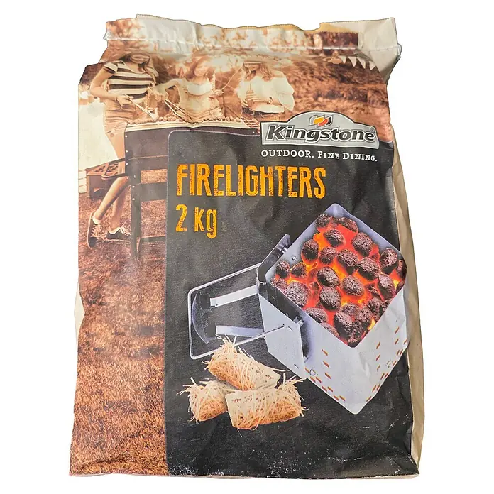 Kingstone Anzündwolle - Holz, 2 kg, Geeignet für: Grills - Kingstone Grillanzünder, 2 kg Beutel. Dunkle Verpackung zeigt glühende Kohlen im Anzündkamin und natürliche Holzwolle-Anzünder.