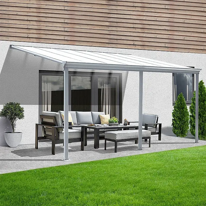 HOME DELUXE - Terrassenüberdachung SOLIS | Farbe: Weiß, Größe: 435 / 442 x 300 / 303 x 278 / 226 cm -  - Weiße Terrassenüberdachung mit transparentem Wellendach und grauem Rahmen, die einen Sitzbereich am Haus überdacht.