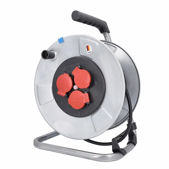 as - Schwabe Metallkabeltrommel 230V 25m H05RR-F 3G1,5 IP44 -  - Graue Metall-Kabeltrommel mit drei roten Schutzkontaktsteckdosen und schwarzem Griff auf Metallrahmen. Made in Germany.