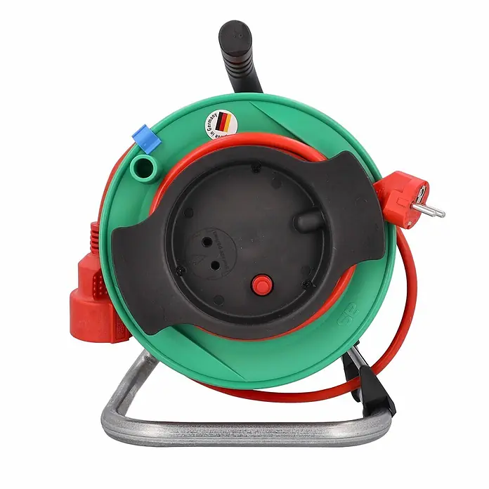 as - Schwabe Gerätekabeltrommel 25m H05VV-F 3G1,5 IP20 -  - Grüne und schwarze Kabeltrommel mit rotem Verlängerungskabel, rotem Stecker, Steckdosen und rotem Reset-Knopf auf Metallständer.