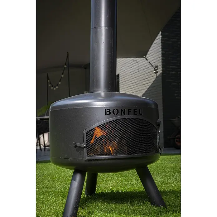 Bonfeu Chimenea de exterior Bongiro - Ø x Al: 55 x 132 cm, Acero, Negro - Chimenea exterior gris oscuro con "BONFEU", mostrando fuego a través de la puerta de malla.
